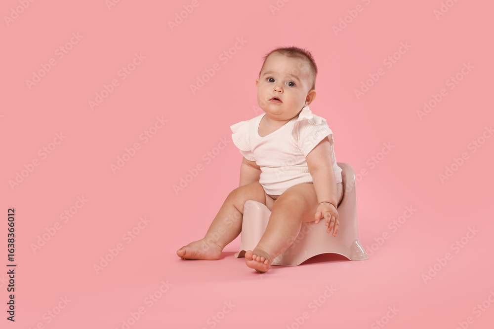 Cute little baby sitting on potty against pink background, space for text Cute little baby sitting on potty against pink background, space for text