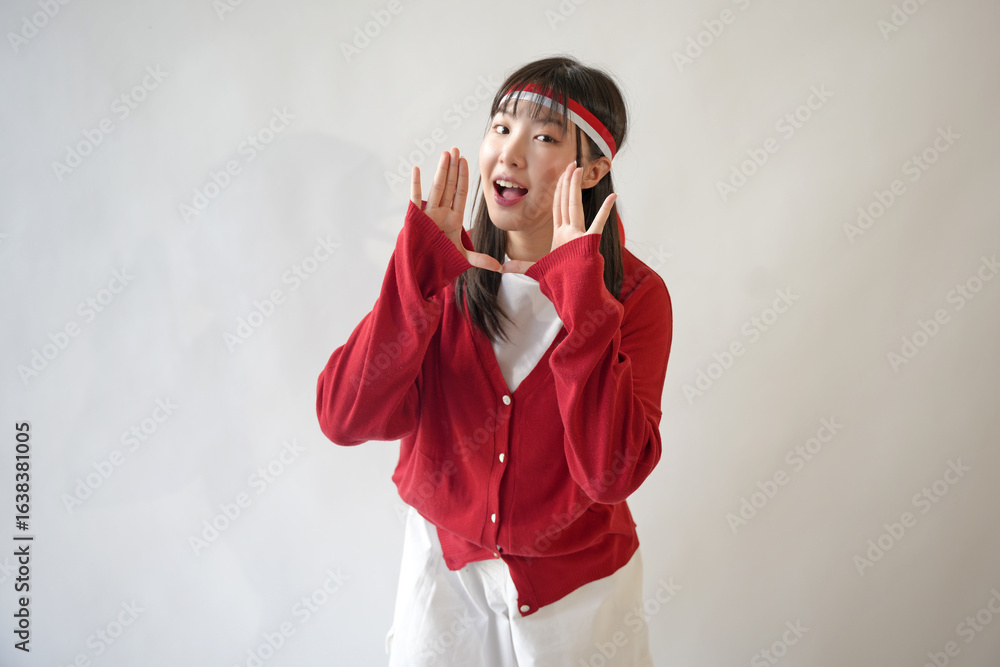 Φωτογραφία Young beautiful woman wearing a red sweater screams and shouts loudly while covering her mouth with her hand