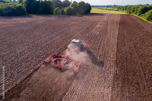 tractor cultivating a field with a harrow