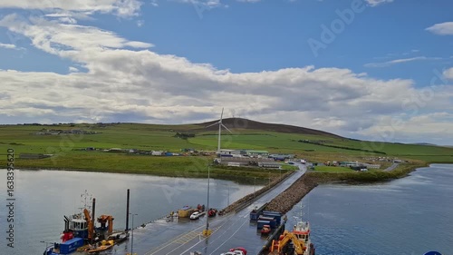 Kirkwall united kingdom aug 9 2024 Scenic Harbor View with Wind Turbine and Lush Green Landscape