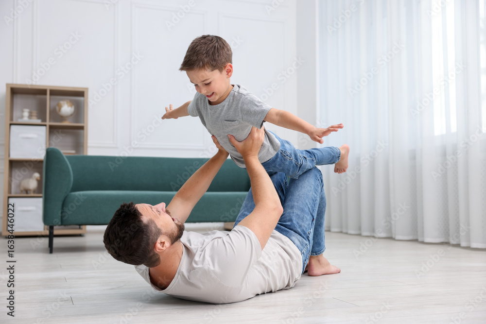 Fototapeta premium Father and his son spending time together on warm floor at home. Heating system
