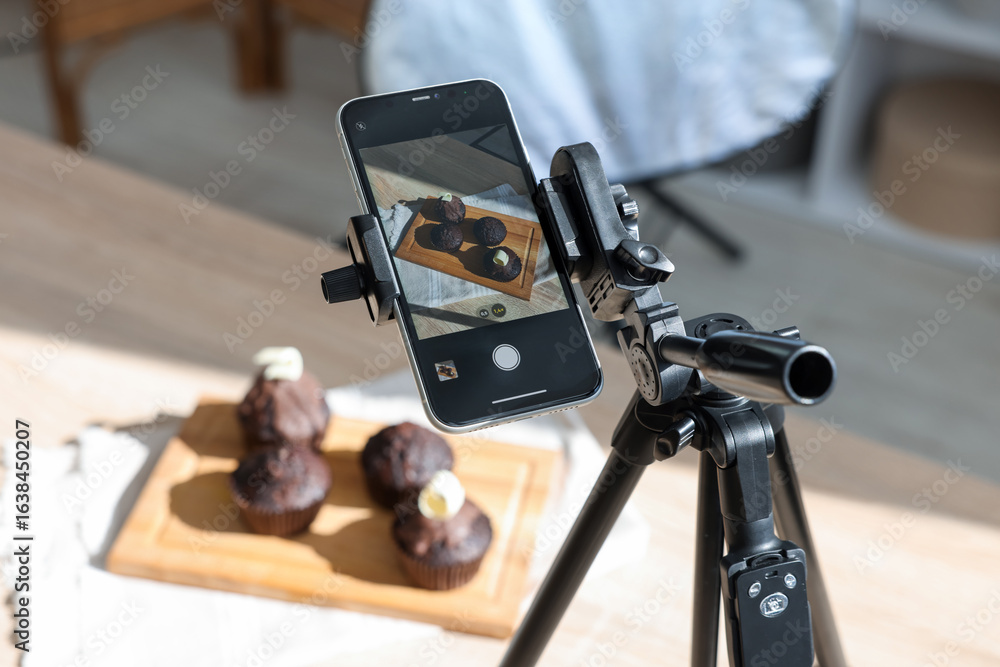 Obraz premium Shooting chocolate muffins with smartphone in studio, closeup. Professional food photography