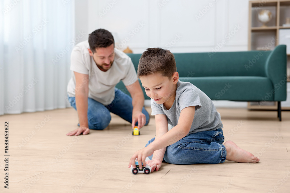 Fototapeta premium Father and son feeling comfortable to play on warm floor at home. Underfloor heating