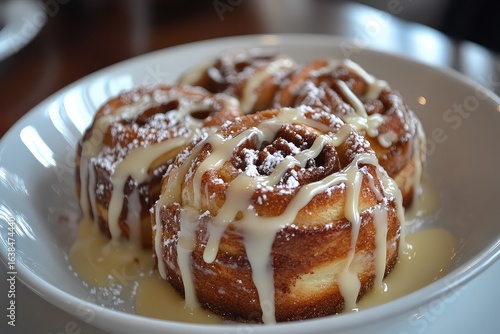 A serving of cinnamon rolls, drizzled with icing and served warm