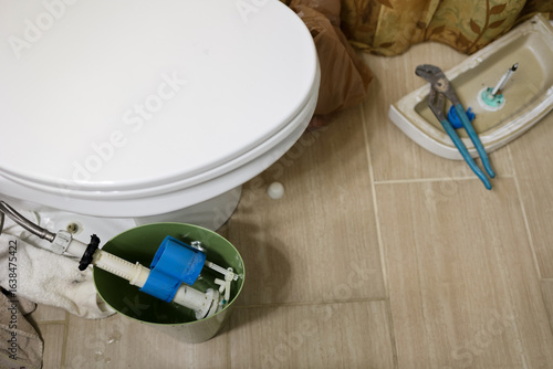 Foto A leaking toilet pipe in a residential bathroom being repaired