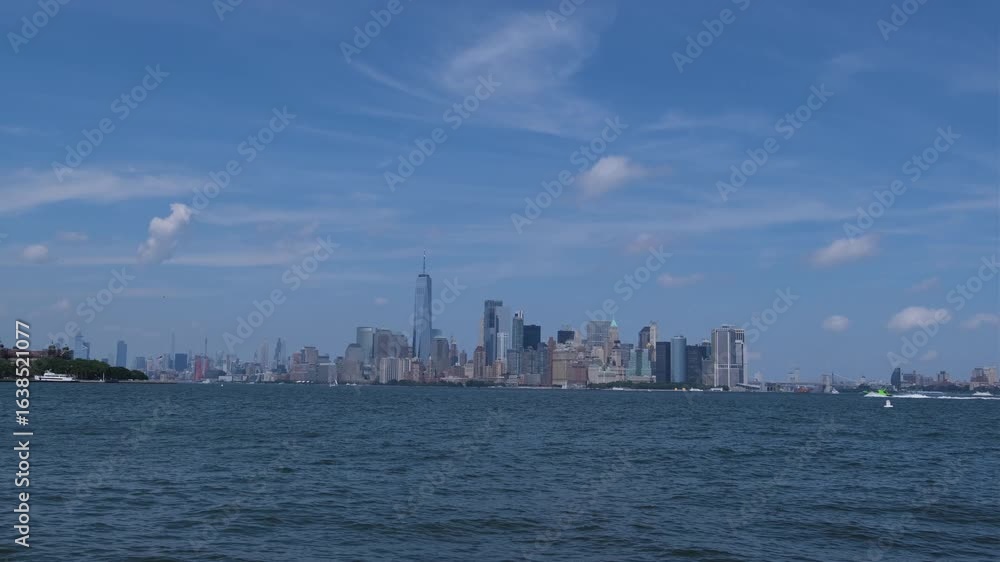 New York skyline over tranquil waters on sunny day. New York skyline over tranquil waters on sunny day.