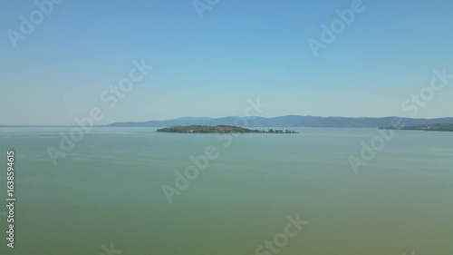 Lake trasimeno island showing in the distance under blue sky
