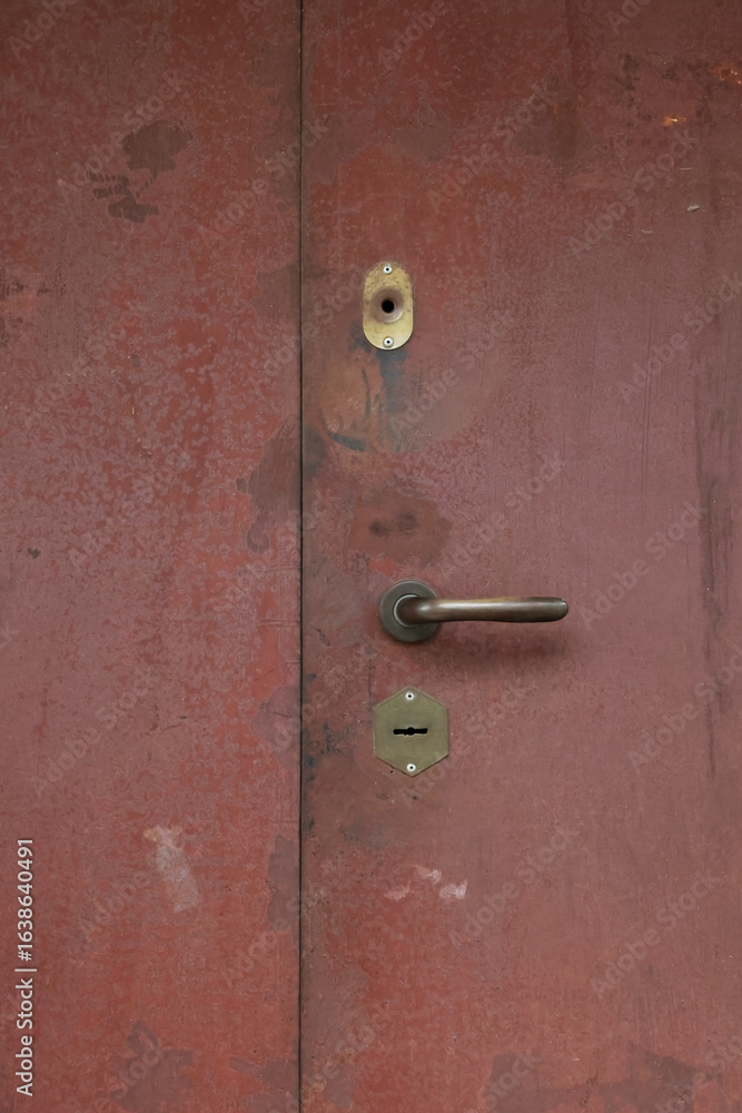 Obraz premium Close Up Of An Old Weathered Red Metal Door With A Handle And Keyhole. Abstract Grunge Texture And Vintage Background. Vertical Shot.