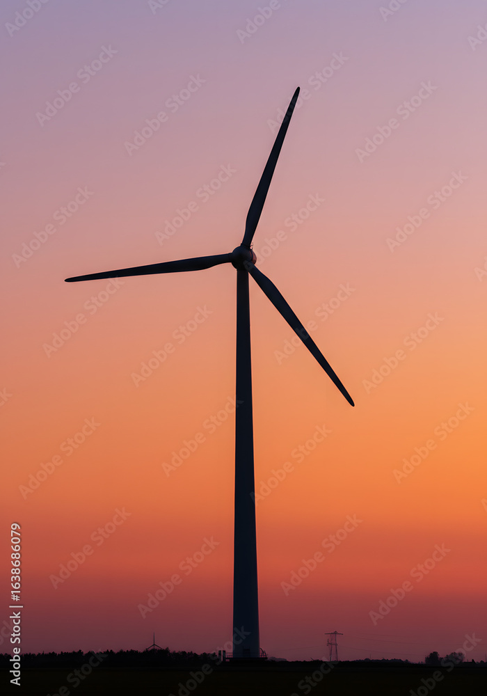 Silhouette of a wind turbine against a vibrant sunset sky with shades of orange and purple hues Silhouette of a wind turbine against a vibrant sunset sky with shades of orange and purple hues