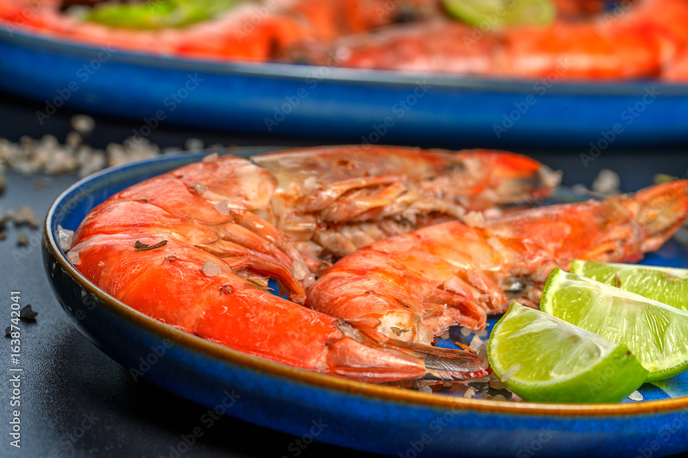 Grilled prawns with lime and coarse salt on blue plate Grilled prawns with lime and coarse salt on blue plate