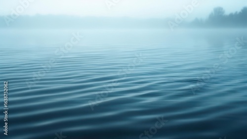 Serene Blue Ripples Flowing into a Thick Morning Mist