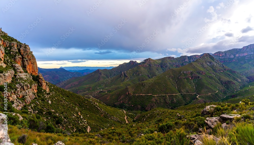 Naklejka premium Lush mountain valley scene under a dramatic sky.