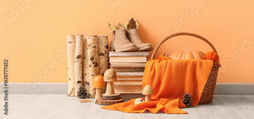 Cuadro en lienzo Books, autumn mushrooms, firewood and boots near orange wall