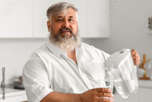 Mature man pouring purified...