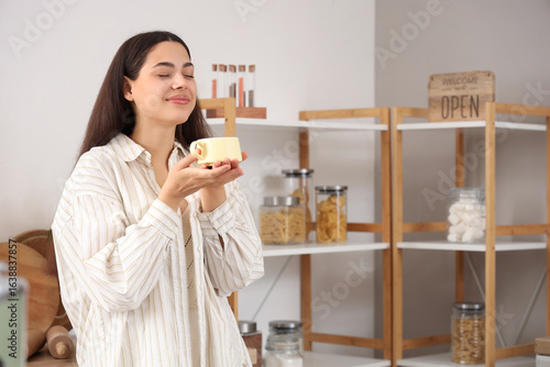 Pretty young woman with cup...