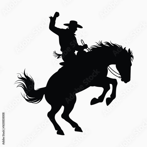 Silhouette of a cowboy riding a bucking bronco horse
