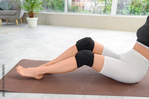 Woman exercising with knee ...
