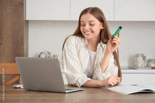 Young woman using laptop an...
