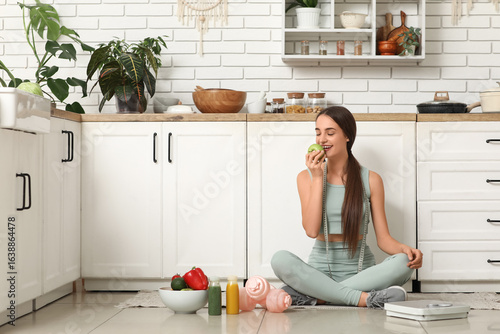Sporty young woman eating a...