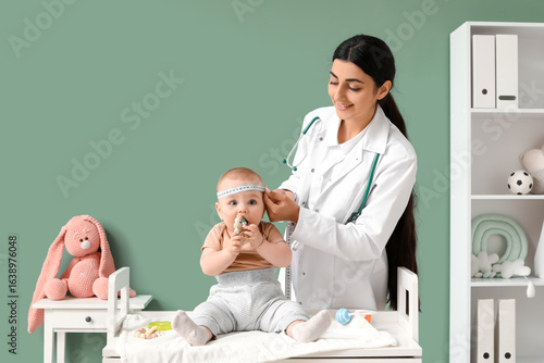 Female pediatrician measuri...