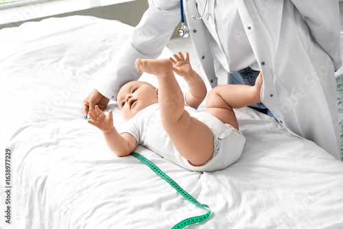 Female pediatrician measuri...