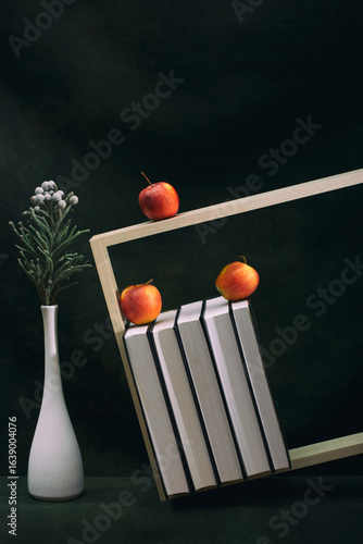 Still life with apples, books and brunia branch