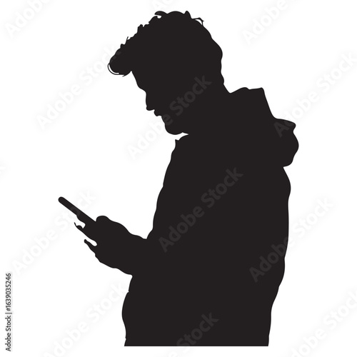 silhouette of a man looking down at the cell phone he is holding