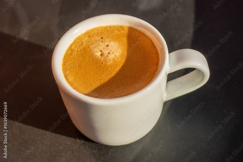 Fototapeta premium View on the cup of coffee during the morning, morning ritual - savoring freshly brewed coffee.