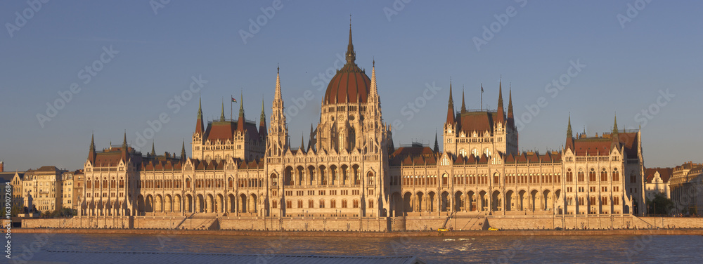 Naklejka premium Panoramic view of the Hungarian Parliament during a mild sunset.