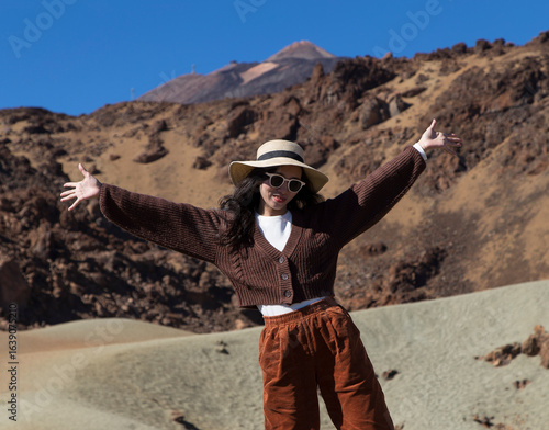 A young beautiful vietnamese woman wearing a hat and sunglasses enjoying in the Mount Teide, Canary Islands, Spain.