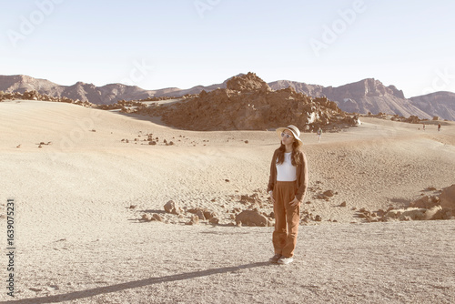 A young beautiful vietnamese woman standing wearing a hat and sunglasses contemplating the Mount Teide, Canary Islands, Spain (2)