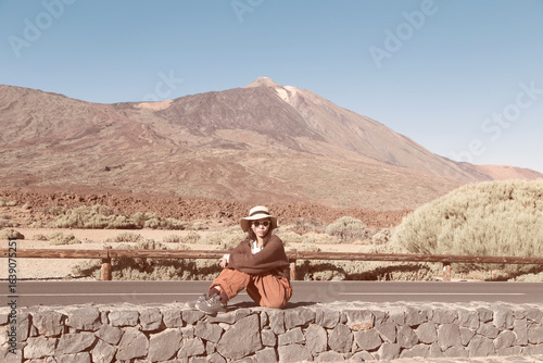 A young beautiful vietnamese woman wearing a hat and sunglasses posing at the Mount Teide, Canary Islands, Spain.