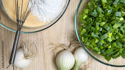 Fotografie Freshly chopped scallions and onions await alchemical whisking with flour, heral