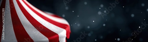 A close-up of a red and white striped circus tent against a dark background, evoking a sense of nostalgia and whimsy.