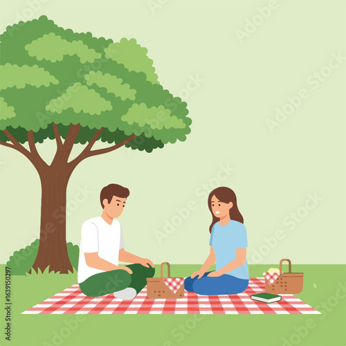 Enjoying a picnic scene with young couple sharing time in nature, creating memories. Picnic scene shows calm atmosphere for relaxing in park, including picnic basket and checkered blanket.