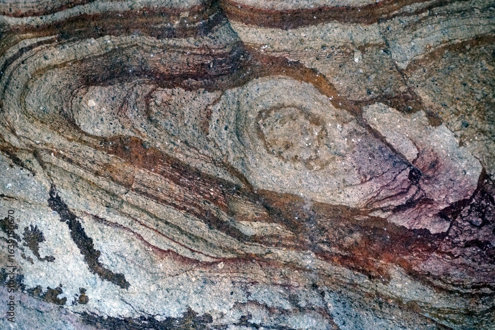 Naklejka premium Texture of the stone surface on the sea coast. Graphics of lines and shades of the structure of the rock.