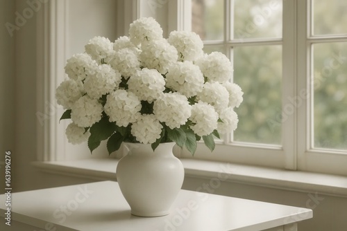 A pristine white vase cradles a bouquet of pure, untouched hydrangeas, their delicate petals whispering softly in the gentle embrace of daylight filtering through the window
