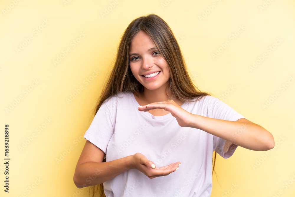 Obraz premium Young caucasian woman isolated on yellow background holding copyspace imaginary on the palm to insert an ad