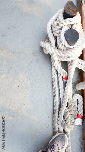 Mooring rope of vessel. Rope tied on ships. Ship’s rope tied on deck for safety. Sailboat rope line at bollards. Mooring bollard with a rope on vessel.