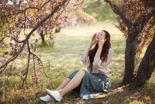 Foto Happy Woman Enjoying Sunshine Under Blossoming Tree in Spring Garden