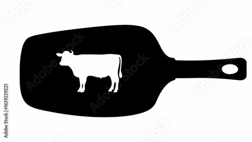 Silhouette of a white cow inside a black spatula with a handle and a hole for hanging it up in kitchen