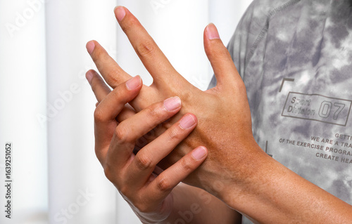 Carta da parati Man pressing aching palm with thumb, visible muscle tension and tendon strain in a bright clinical environment