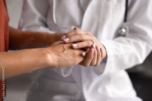 Foto Young doctor woman holding hands of patient, making supportive gesture, giving compassion, empathy, hope, comfort, encouraging for difficult treatment, therapy