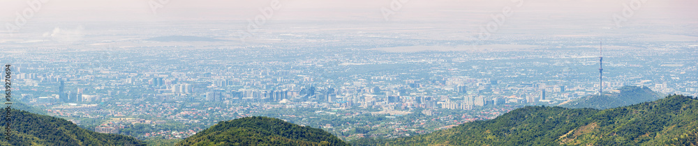 Obraz premium Urban skyline of Almaty, Kazakhstan, seen from the surrounding mountains, highlighting the Kok Tobe TV Tower and vast cityscape