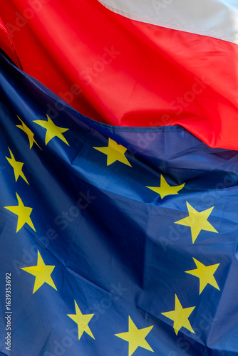 Krakow, Poland, August 6, 2025. Polish flag and European flag on the facade of a building in Krakow.