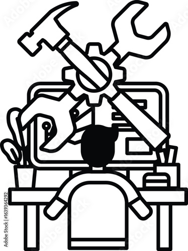 A man is sitting at a desk with a computer and a toolbox