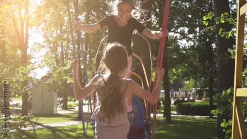 Slow Motion: Two sisters ride on swing