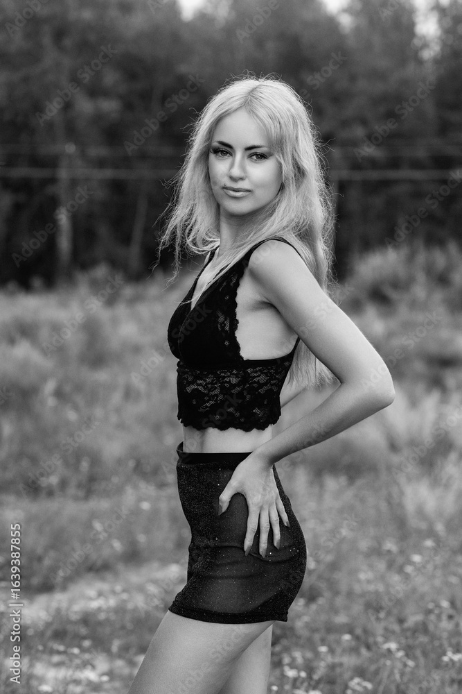 Portrait of a young beautiful blonde girl in light clothes outdoors in summer. Black and white photo. Portrait of a young beautiful blonde girl in light clothes outdoors in summer. Black and white photo.