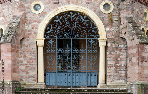 Historic Ornamental Iron Gate with Arched Entry and Stonework Design