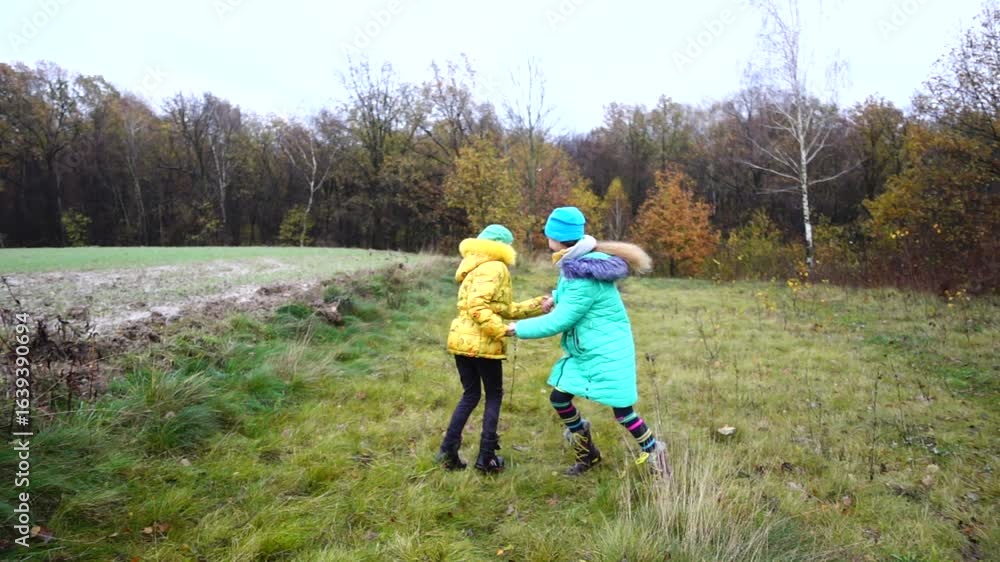 Slow motion two little sisters are spinning in a round dance in a beautiful autumn nature. Slow motion two little sisters are spinning in a round dance in a beautiful autumn nature.